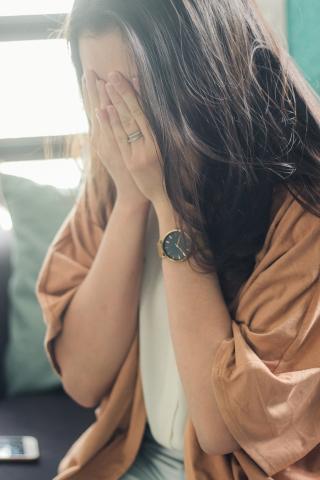 Vrouw met handen voor haar gezicht